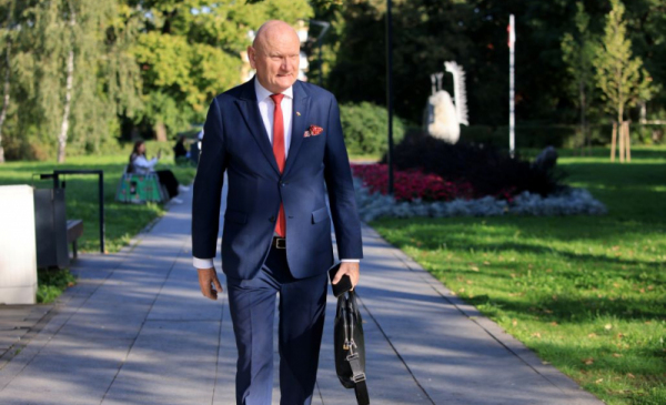 Na zdjęciu: ubrany w garnitur prezydent Michał Zaleski, trzyma w ręce teczkę i idzie chodnikiem wzdłuż zieleni